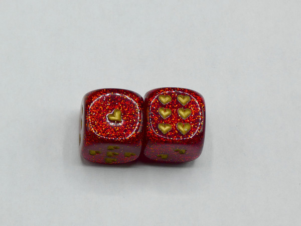 A pair of two 16mm d6 Glitter Ruby Red Dice with Gold Heart pips.