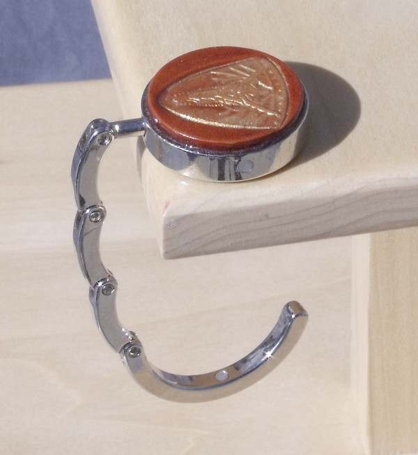 An open purse hook hanging off the edge of a table.