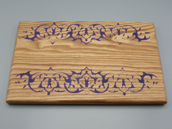 A small serving board in Kentucky coffeenut with a mirrored purple epoxy tribal design  along the long edges.