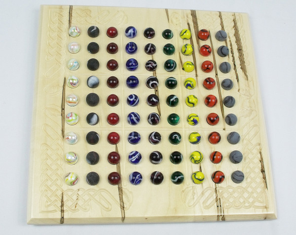 Top-view of the Sudoku board in ambrosia maple with all of the marbles on the board.
