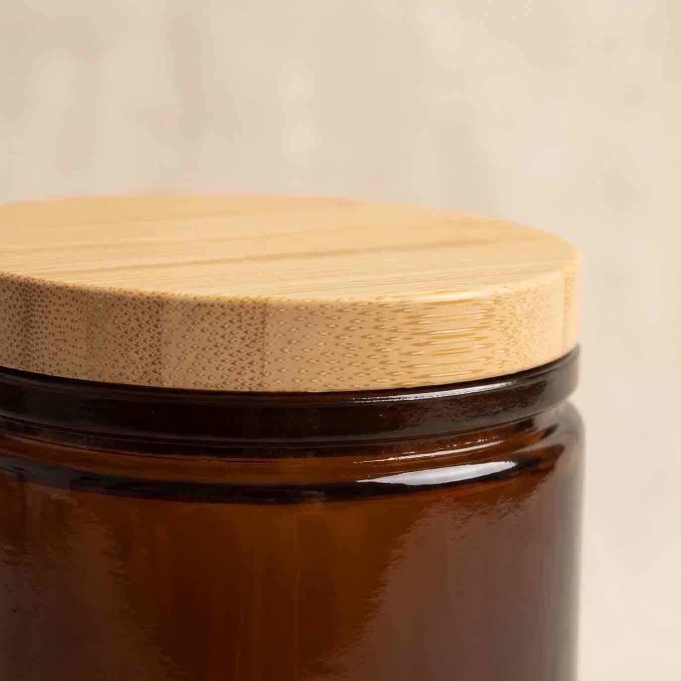 Neo 10 Natural Bamboo Lid 80mm close-up showing bamboo grain texture, distinctive edge-grain dot pattern, and smooth cork-finish rim on Dark Amber Calypso jar