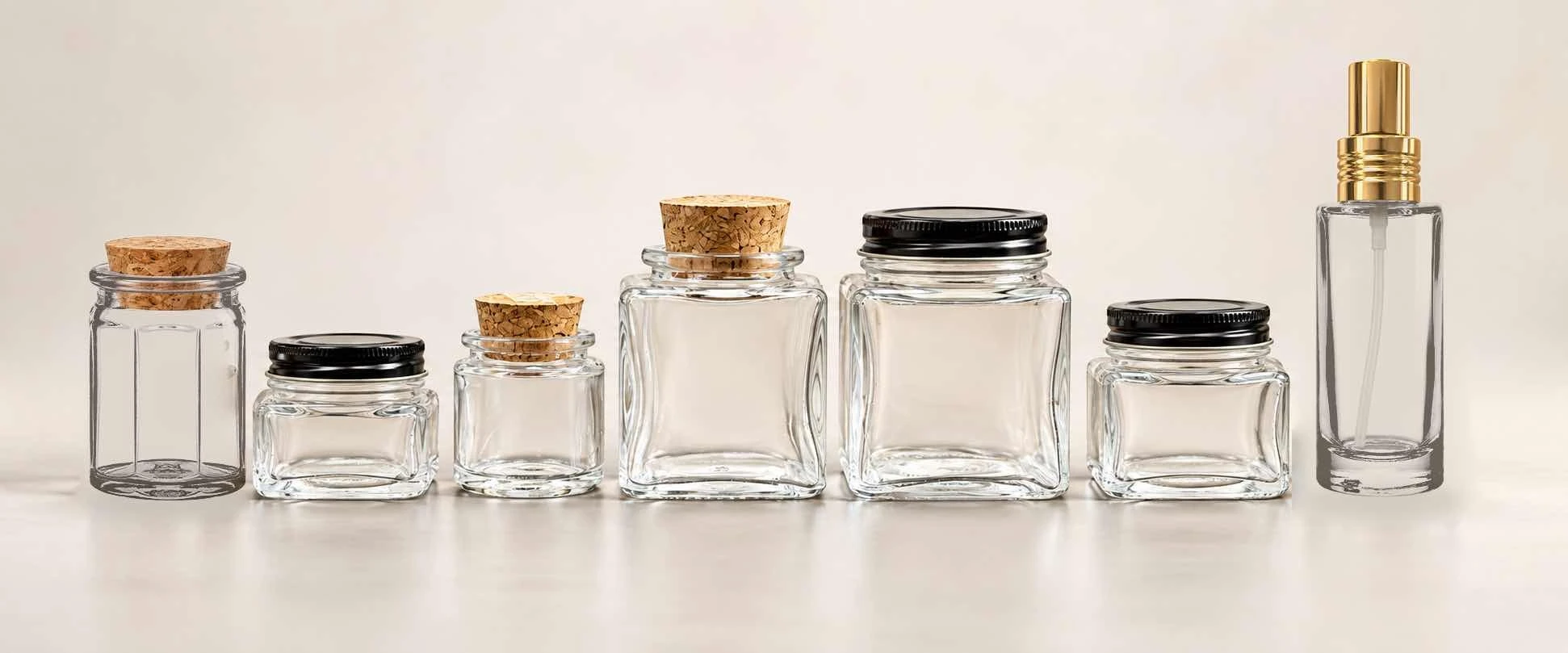 Lineup of small clear square glass jars with cork and black screw cap closures for gift-sized packaging