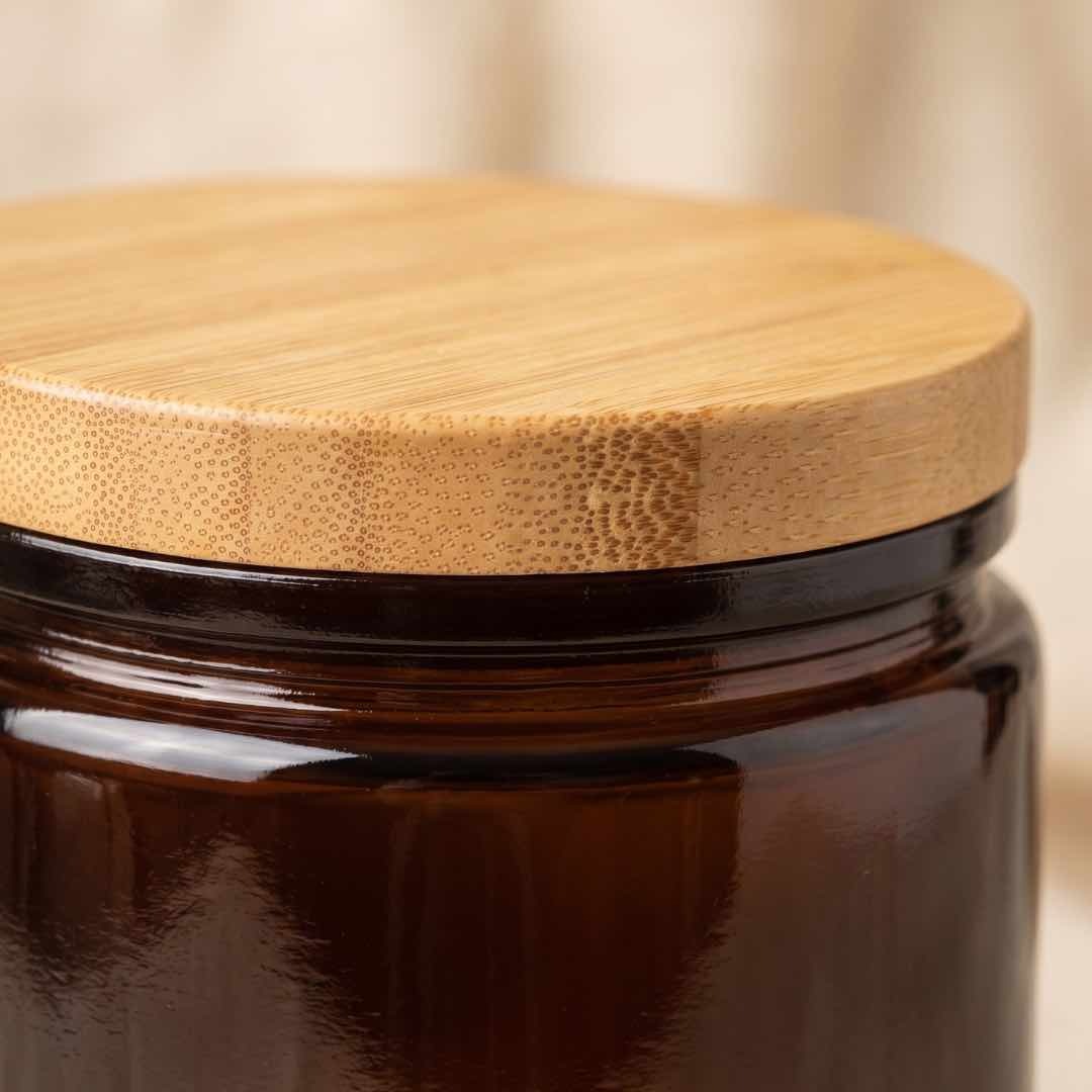 Neo 10 Natural Bamboo Lid 88mm close-up showing unique bamboo grain texture, dotted edge-grain pattern, and smooth cork-finish rim on Dark Amber Calypso jar