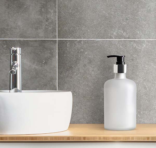 White soap dispenser by bathroom sink