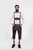 A man wearing earthy brown leather Zwiesel Suspenders with intricate Bavarian embroidery and circular metal clasps, paired with a white shirt, matching Zwiesel Bundhosen, brown shoes, and socks.