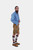 Full-length side profile of a man in lederhosen, emphasizing the length and fit of the shorts and detailing on the suspenders.