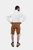 Back view of a man wearing a white dress shirt and brown lederhosen. The back of the lederhosen is plain compared to the front, and he has his hands on his hips.