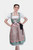 A woman wearing a green dirndl with pink lace accents, standing with her hands on her hips, looking confidently at the camera. The dirndl has a black ribbon tied at the waist and a white blouse underneath.