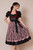 Midi dirndl Peri Baumeister by eLederhosen, Wadenlange cut in Venetian Ruby with black Mieder, rose leaf-lace apron, and silver Charivari chain, front view