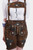 A close-up of a woman wearing earthy brown leather lederhosen with intricate green and white floral embroidery, paired with a white shirt and suspenders.