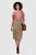 Woman wearing a brown traditional Bavarian leather skirt with embroidery and a white blouse on a plain background.