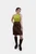 A full-body view of the same woman in the lime green top and brown leather skirt. She is also wearing knee-high brown boots, with one hand on her hip and the other resting by her side, posing confidently against a plain white background.