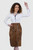 Woman wearing a brown leather skirt with white shirt on a white background
