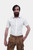 Close-up of a man wearing a short-sleeved white shirt and brown leather lederhosen. The man has his right hand in the pocket of the lederhosen, showcasing the texture and details of the leather shorts and the simple design of the white shirt.