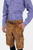 Side profile of a man wearing a blue and white checkered dress shirt and brown cargo lederhosen with pockets. He has his left hand in his pocket and is looking slightly towards the camera.