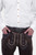  A close-up view of Monte Carlo Bundhosen, focusing on the detailed embroidery and decorative belt buckle. The man is wearing a white button-down shirt, with his hands casually placed in the pockets of the Bundhosen.