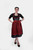 Full-length front view of a woman posing in the Dirndl Kelly, showing off the detailed lace skirt and contrasting black blouse.