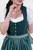 Close-up view of a woman in Dirndl Sukowa, focusing on the green bodice with metal buttons and the neckline of the white blouse.
Grünes Dirndl