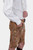 Another side view of the man wearing Leavenworth lederhosen, showing the detailed embroidery and button details on the side of the shorts.