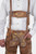 Close-up of a man wearing Leavenworth lederhosen with suspenders. The suspenders are adorned with a silver buckle, and the lederhosen feature intricate yellow and green embroidery.