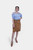 Close-up view of a Clara Lederhosen skirt, showcasing the detailed texture of the brown leather material and the decorative belt buckle, with the woman crossing her arms over her blue and white checkered blouse. lederrock midi