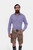 A bearded man wearing a blue checkered shirt paired with traditional brown DanubeLederhosen with intricate embroidery, standing against a white background.