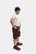 Another full-body front view of a boy in Sebastian Lederhosen in Cocoa Rust, standing confidently with hands on hips.