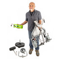 Person holding a folded TravelScoot Escape frame upright and its battery separately, with removed components on the floor.