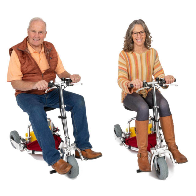 Man and woman riding two TravelScoot mobility scooters