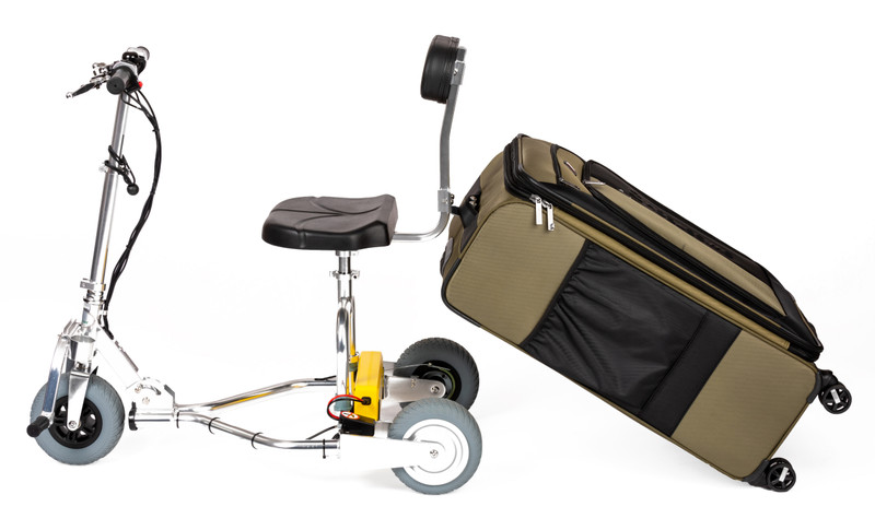 Full side view of the TravelScoot mobility scooter towing a large piece of luggage behind it using the rear luggage kit.