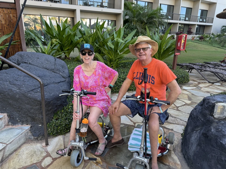 Two TravelScoot owners enjoying a vacation with their scooters