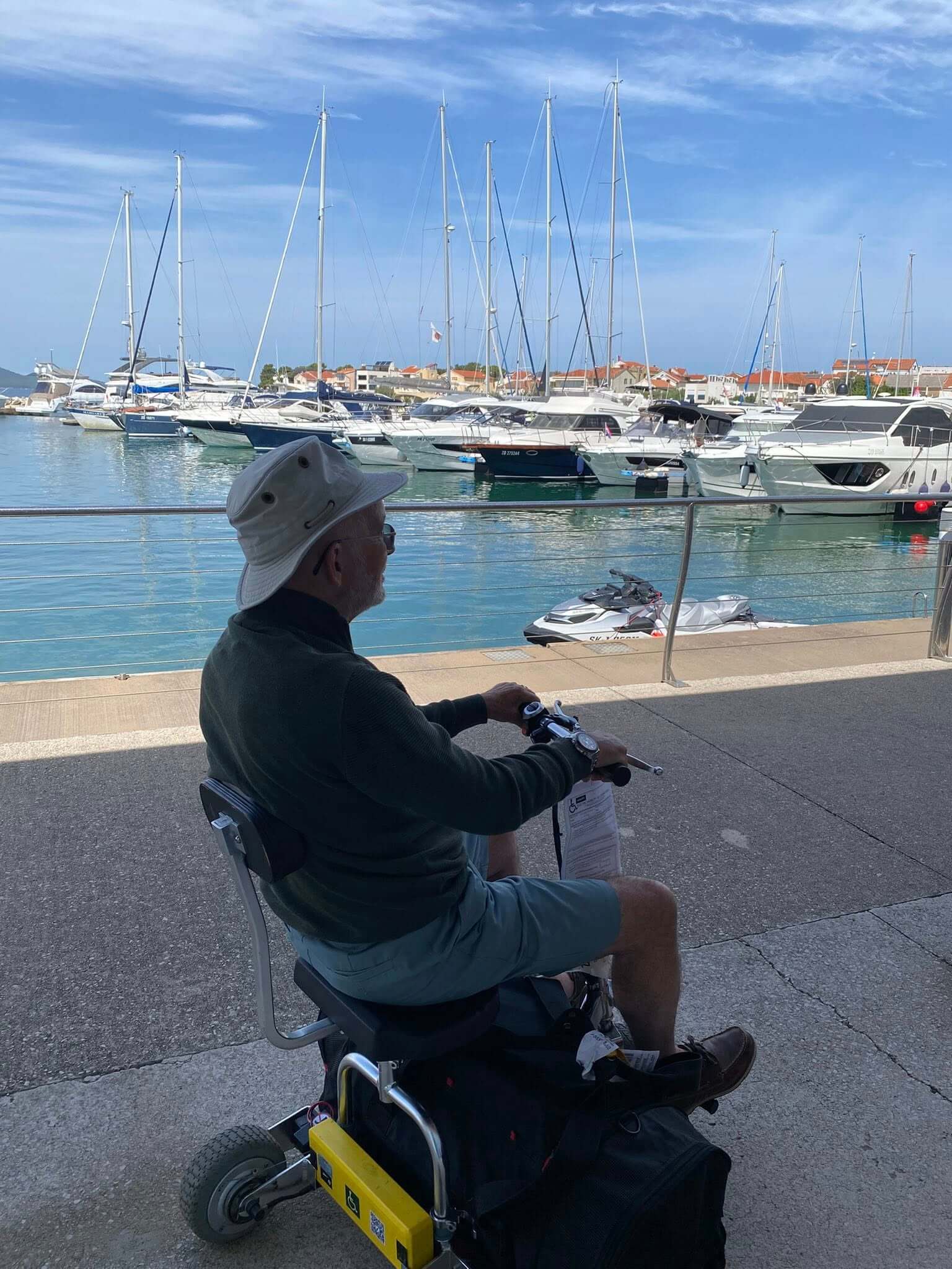 Person on a mobility scooter looking out over a lake.