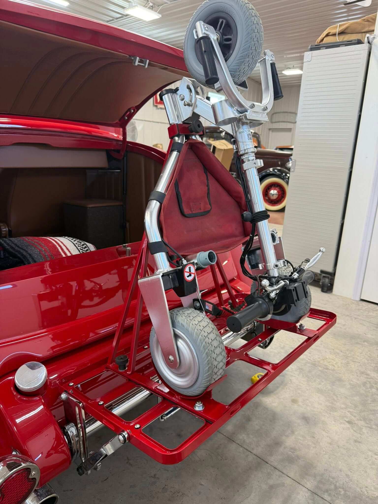 Red classic car carrying TravelScoot mobility scooter