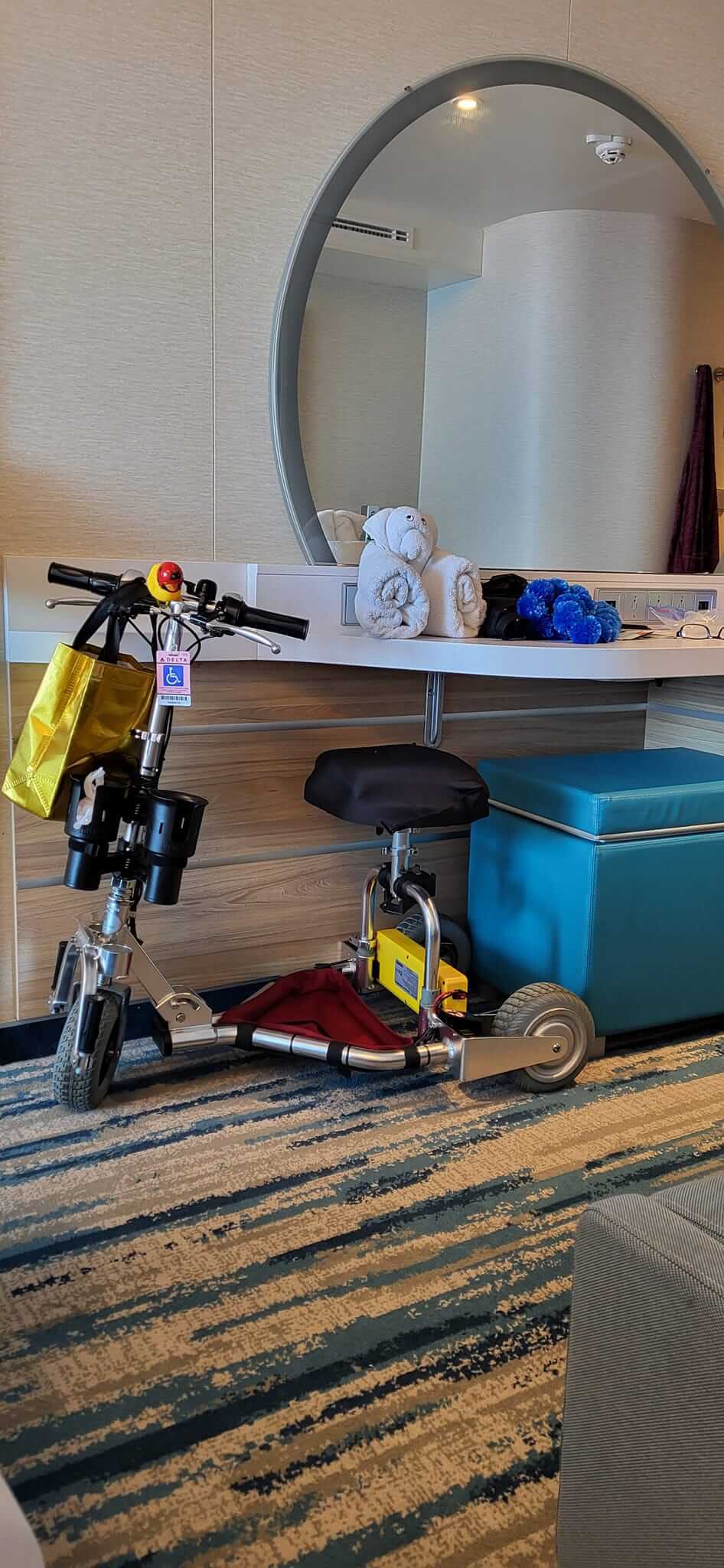 Mobility scooter under a storage desk on a crruise.