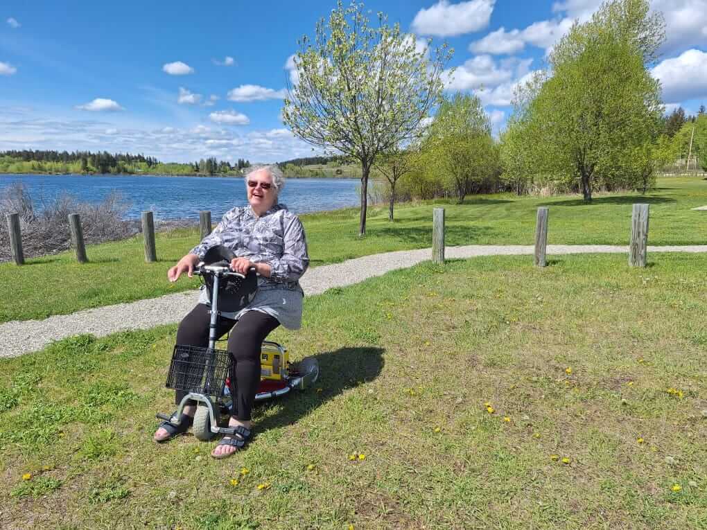 Mobility scooter on grass in front of a lake.