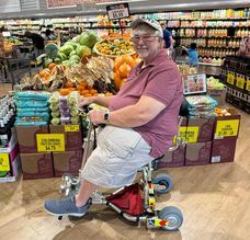 Man in grocery store on a travel scooter.