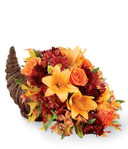 This unique cornucopia is overflowing with bright lilies, fall daisies, and orange roses. It is a perfect way to celebrate thankfulness this season!