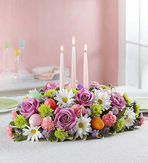 In the Garden Centerpiece contains lavender roses, white daisies, pink mini carnations, green buttons, fresh greens and three taper candles. It even has hidden Easter eggs!