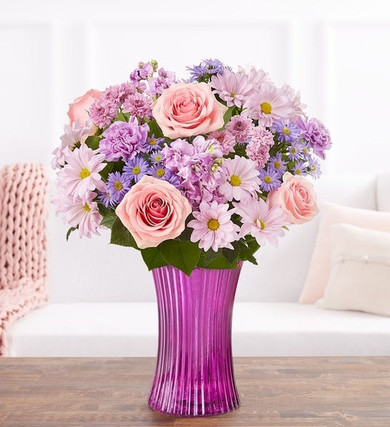 This lavender gathering vase holds a collection of pink roses, happy daisies and soft purple stock, carnations, and asters.  If you'd like to give sunshine on a cloudy day, we are talking about the My Girl Bouquet.