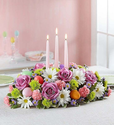 In the Garden Centerpiece contains lavender roses, white daisies, pink mini carnations, green buttons, fresh greens and three taper candles. It even has hidden Easter eggs!
