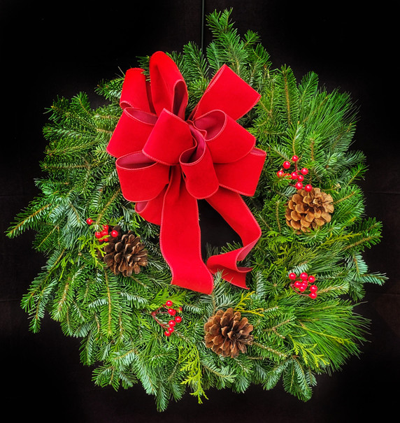 This classic wreath is handmade by our design team with fresh cut greenery. Real white pine, cedar and fir woven together and decorated with three natural pinecones, red berries and a stunning bow to tie the look together. The wreath frame is 12" in diameter.