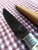 Deer bone handle patch knife with poured pewter bolster closeup of left side of blade