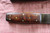 Large hand forged skinning knife with curly maple handle and riveted sheath
