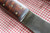 Large hand forged skinning knife with curly maple handle and riveted sheath