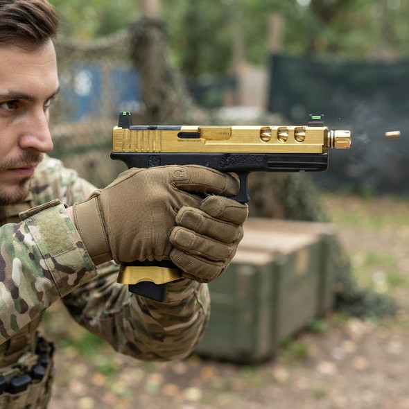 A person in tactical gear firing the Vorsk EU18 Vented Gas Blowback Airsoft Pistol in Gold at an outdoor range.