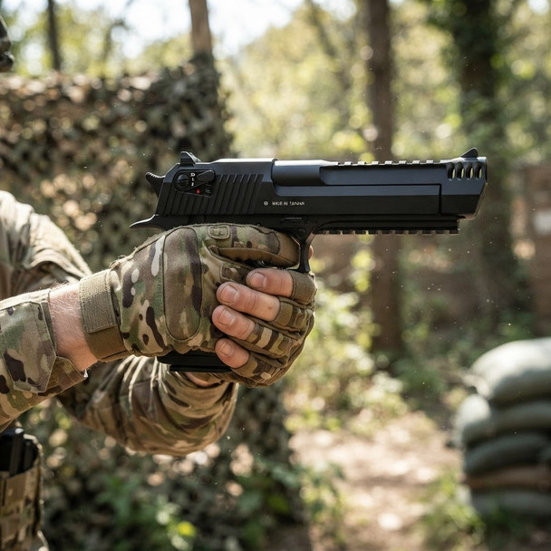 KWC Desert Eagle L6 .50AE Co2 Blowback Airsoft Pistol in Tactical Black, side view held in a woodland game