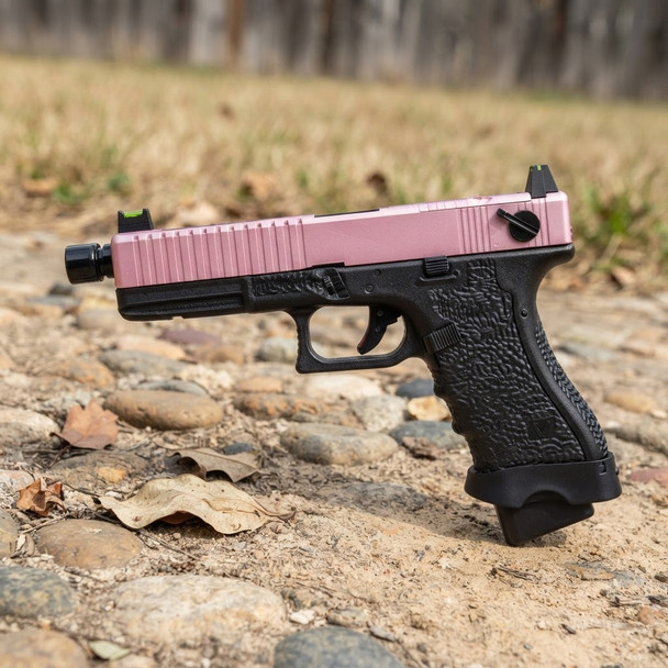 Side view of VORSK EU17 Tactical Gas Blowback Airsoft Pistol in Pink & Black on rocky ground