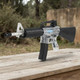 Blackviper B3803 M4 Fully Auto Airsoft Rifle in Clear/Black, angled front view on an outdoor wooden table