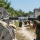 Blackviper B3803 M4 Fully Auto Airsoft Rifle in Clear/Black held beside wooden barriers outdoors