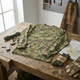Kombat UK - Long Sleeved T-Shirt in BTP (British Terrain Pattern) Camouflage laid flat on a rustic wooden table with gear.